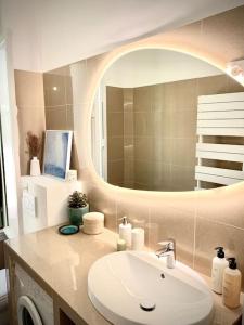baño con lavabo y espejo grande en Superbe 3 pièces - 30m de la mer - Terrasse - Clim - Parking, en Saint-Raphaël