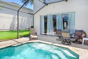 a swimming pool with two chairs and a table at Veteran Owned 3bdr/3 bath Townhouse w/WiFi 3mi to Disney - Winter/Spring Specials in Kissimmee