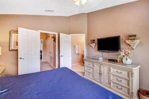 a bedroom with a bed and a tv on a dresser at Veteran Owned 3bdr/3 bath Townhouse w/WiFi 3mi to Disney - Winter/Spring Specials in Kissimmee