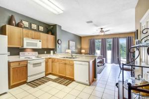 a kitchen with wooden cabinets and white appliances at Veteran Owned 3bdr/3 bath Townhouse w/WiFi 3mi to Disney - Winter/Spring Specials in Kissimmee
