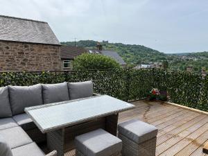 a patio with a couch and a table on a deck at Matlock Maisonette in Matlock