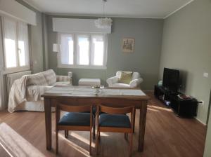 ein Wohnzimmer mit einem Tisch und 2 Stühlen in der Unterkunft Casa Botta. Ampio appartamento luminoso e confortevole in Morbegno
