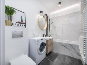 y baño blanco con lavadora. en Apartament na Rybakach, en Gdansk