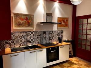 a kitchen with white cabinets and black and white tiles at Appartement Signature Art Déco in Valence