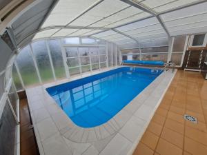 an indoor swimming pool with a glass ceiling at O Arrequento in Oleiros