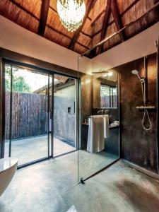 ein Bad mit einer Glasdusche und einem Waschbecken in der Unterkunft Kruger Eden Lodge in Marloth Park