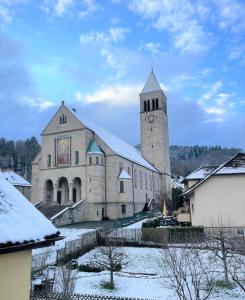 una grande chiesa con una torre dell'orologio nella neve di Alte Schule, Ferien- und Monteurwohnung a Gernsbach