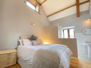 a bedroom with a bed and a sink at Heronston Barn Cottage in Bridgend