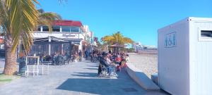 a group of people sitting in chairs on the beach at Beautiful Modern Apartment second line to the beach in Lo Pagán