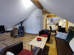ein Wohnzimmer mit einem Tisch, Stühlen und einem Kamin in der Unterkunft Penthouse Aineckblick in Sankt Margarethen im Lungau