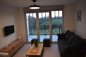 salon z kanapą i dużym oknem w obiekcie Le Saint Pierre en Baie Appt 3-4 pers parking privé w mieście Saint-Valéry-sur-Somme