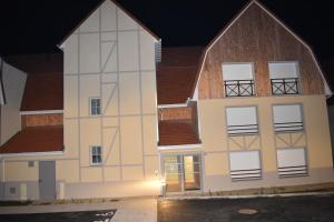 duży biały budynek z brązowym dachem w obiekcie Le Saint Pierre en Baie Appt 3-4 pers parking privé w mieście Saint-Valéry-sur-Somme