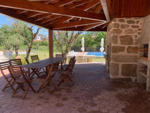 Vinhalにある6 bedroom countryhouse with pool - Casa do Sepiãoの木製テーブルと椅子付きのパティオ