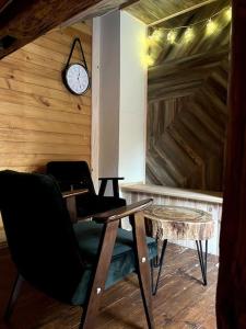 a room with a desk and a clock on a wall at Drewniana chata nad stawem in Krasiczyn