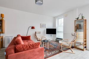 a living room with a red couch and two chairs at Modern Spacious Bright 1-Bedroom Ground Floor Flat in Oxford