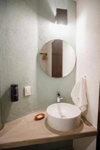 a bathroom with a white sink and a mirror at Hotel Camino Del Sol in Puerto Escondido