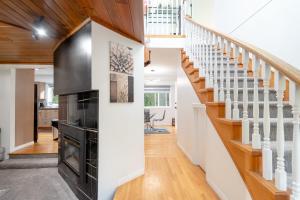 a living room with a fireplace and stairs at Spacious & Modern by the Beach in White Rock