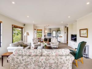 - un salon avec un canapé et des chaises dans l'établissement Busby Hill Villa - Havelock North Holiday Home, à Havelock North