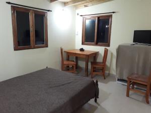 1 dormitorio con 1 cama, mesa y sillas en Complejo El Aljibe en La Lucila del Mar