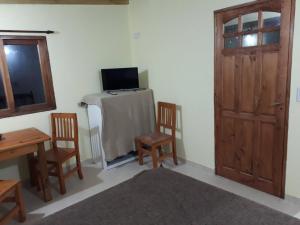 Habitación con mesa, 2 sillas y puerta en Complejo El Aljibe en La Lucila del Mar