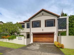 a bedroom house with a garage at Busby Hill Villa - Havelock North Holiday Home in Havelock North