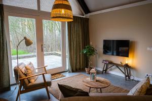 una sala de estar con una gran puerta corredera de cristal en Gastenverblijf de Vense Weide, en Venlo