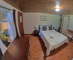a bedroom with a large white bed and a table at Casa Jungle Monteverde B&B in Monteverde Costa Rica