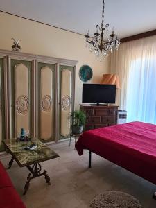 聖雷莫的住宿－Casa dell amore 3，一间卧室配有红色的床和一台平面电视