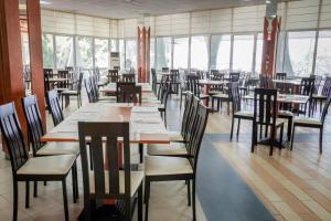 - une salle à manger avec des tables, des chaises et des fenêtres dans l'établissement Laguna Beach Hotel, à Albena