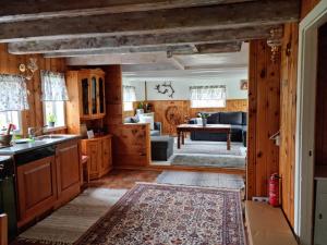 a kitchen and living room with wooden walls at Polar Cottage House Bodø in Nygårdsjøen