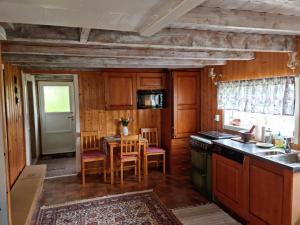 a kitchen with wooden cabinets and a table with a tableablish at Polar Cottage House Bodø in Nygårdsjøen