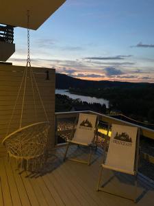 two chairs and a table on a deck with a view at Amaretto Apartamenty-Solina z sauną i ruską banią in Solina