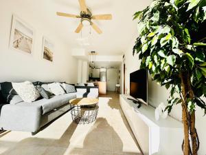 a living room with a couch and a tv at Apartamento con Piscina y Jardín Espectacular Cala Sirenas - Nuevo in Miami Platja