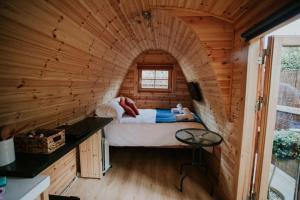 1 dormitorio en una cabaña de madera con 1 cama. en River Side Cabin with Hot tub Snowdonia, en Barmouth