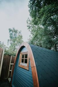una pequeña casa azul con una ventana encima en River Side Cabin with Hot tub Snowdonia, en Barmouth