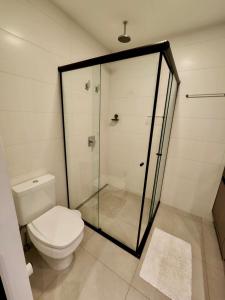 a bathroom with a toilet and a glass shower at A Melhor Vista de Campo Grande in Campo Grande