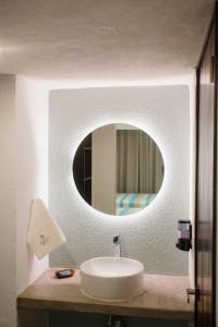 y baño con lavabo y espejo. en Hotel Camino Del Sol, en Puerto Escondido