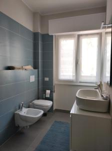 baño con lavabo y aseo y ventana en Casa Botta. Ampio appartamento luminoso e confortevole, en Morbegno