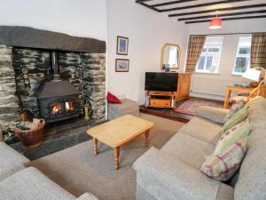 a living room with a fireplace and a couch at Arwel in Capel Garmon