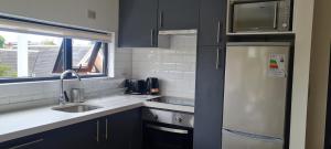 eine Küche mit Spüle und Kühlschrank in der Unterkunft Patagonia Route Apartments in Puerto Varas