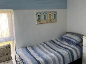 um quarto com uma cama e uma pintura de casas na parede em Meadow View em St. Agnes