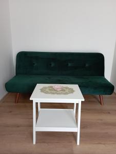 un sofá verde con una mesa de centro blanca y un banco verde en Spa Apartmán Kováčová en Kováčová
