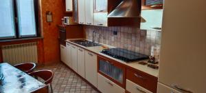uma cozinha com armários brancos e um forno com placa de fogão em Casa vacanze - House Stop and Go em Busto Arsizio