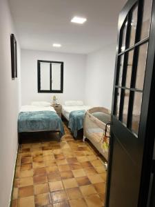 a room with two beds and a door in it at La casa Linda con terraza y vistas al mar in Calonge