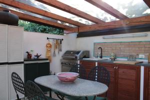 a kitchen with a table with chairs and a sink at La Quintecita villa con piscina privata - vicino Catania e Etna in San Giovanni la Punta