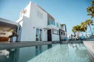 uma casa com piscina ao lado de um edifício em Tsolias Apartments em Protaras