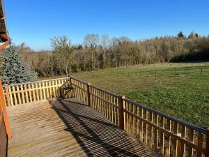 a wooden deck with a bench on top of a field at The Lodge at Meadow Hope in Hereford