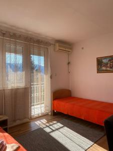 - une chambre avec un lit rouge et une fenêtre dans l'établissement Bisa, à Sokobanja