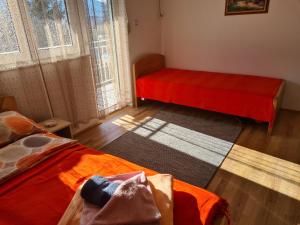 - une chambre avec 2 lits et une couverture rouge dans l'établissement Bisa, à Sokobanja