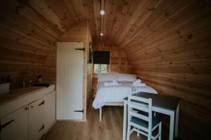 a bedroom with a bed in a wooden room at Ash WINTER RETREAT- Hot tub & Log Bruner in Barmouth